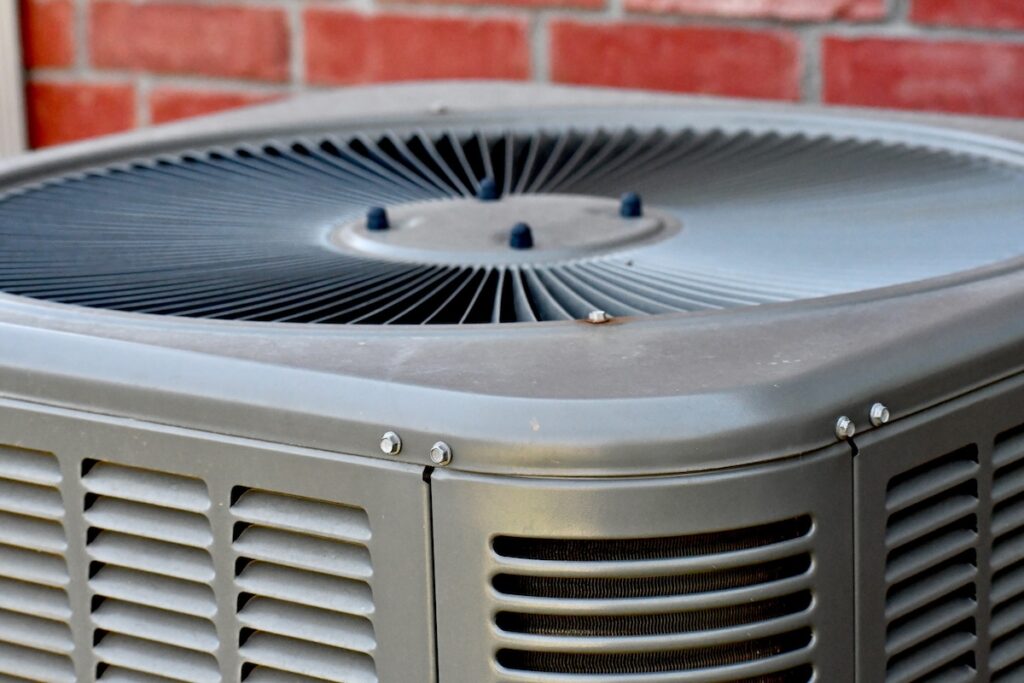 Outdoor air conditioning unit with brick wall background forced air vs central air