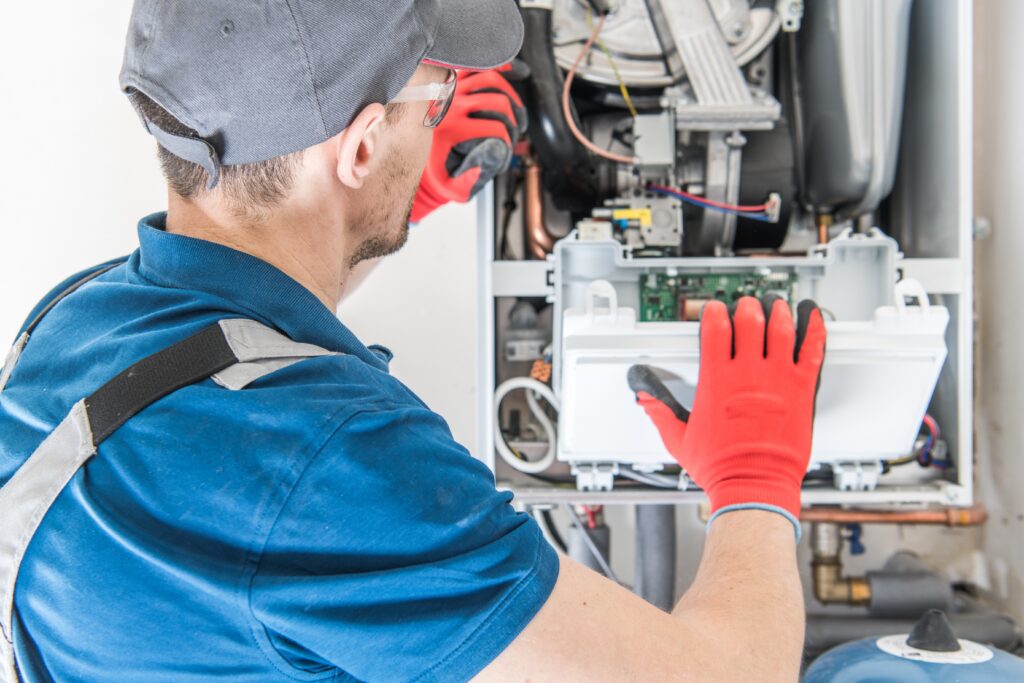 furnace ignitor Heating Central Gas Furnace Issue. Technician Trying To Fix the Problem with the Residential Heating Equipment.