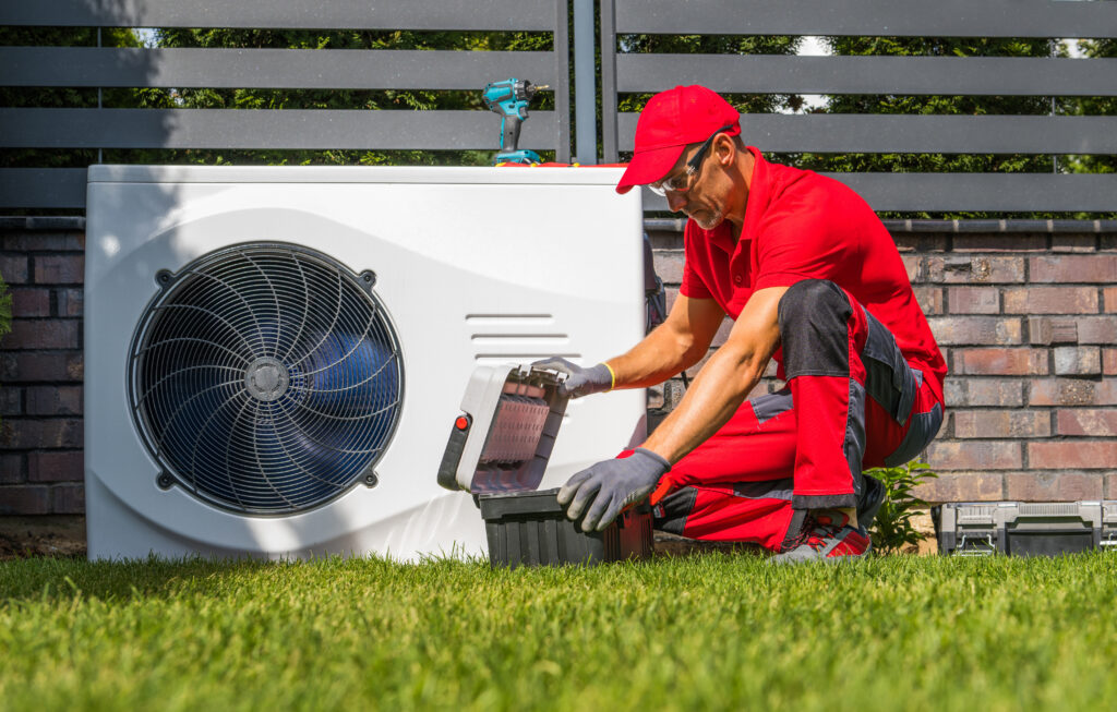 heat pump repair Professional Caucasian Heat Pumps Technician in His 40s Installing New Residential Modern Heating Device. HVAC Industry Theme.