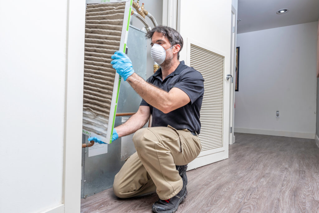 hvac inspection Hvac maintenance technician removing a diry air filter from a heat pump
