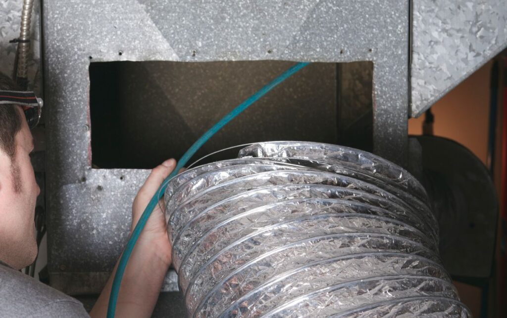 A ventilation cleaner man at work with tool