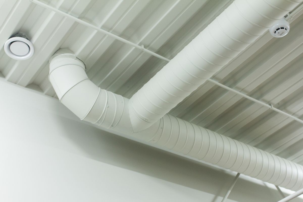 White spiral ventilation duct t-junction on ceiling for industrial hvac system website design